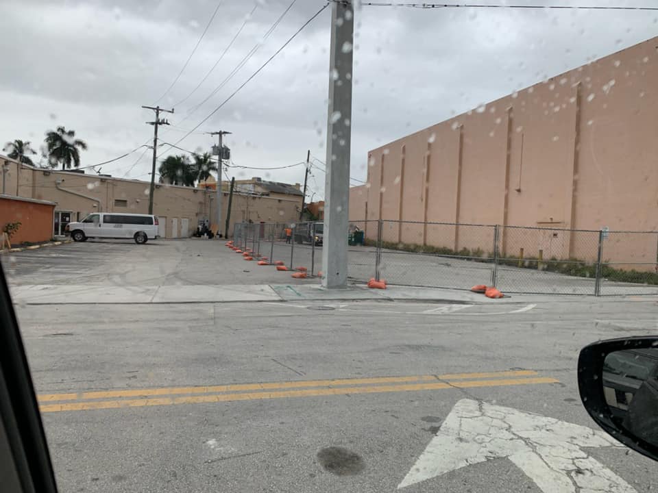 Fenced in area of construction by old theater.