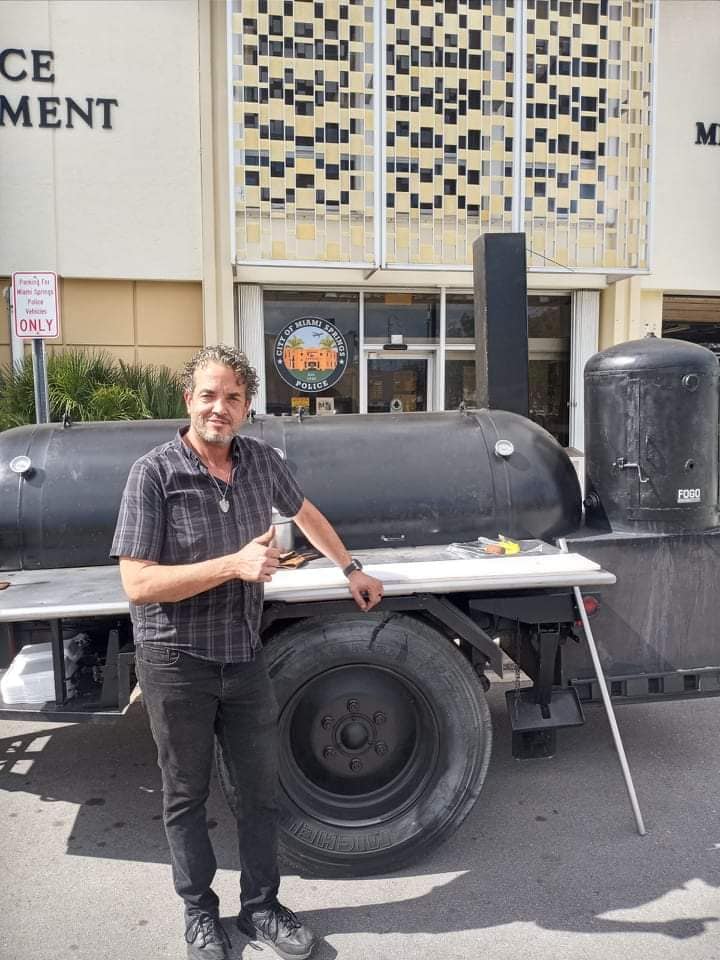 Jimmy Pino from Magic City Smokehouse with his portable smoker in front of the Miami Springs Police Department