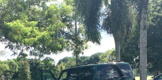 Miami Springs Police Caught Helping Community Miami Springs Police Motorman Assisting Driver with Flat Tire (photo credit: Yvette Bunuel)