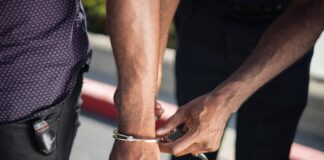 How Do I Protect My Rights When I Have Been Arrested? Police Officer Putting Handcuffs on Another Person