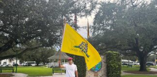 Local Activist Demonstrates on the Circle in Support of Charlie Kirk Activist waving flag in support of Charlie Kirk